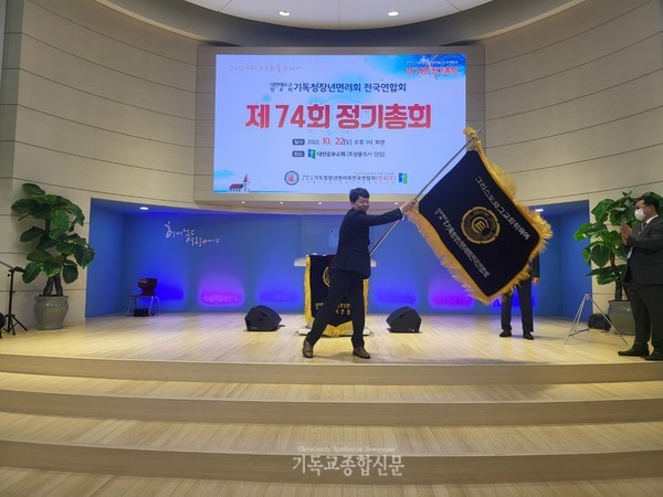 제74회기 회장이 된 김재규 집사가 기를 흔들고 있다.