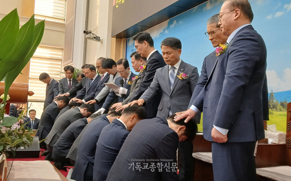 안수집사에게 안수 기도를 하고 있다.